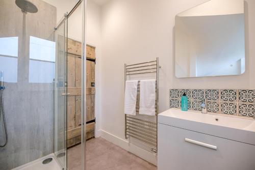 a bathroom with a glass shower and a sink at The Artist's House in Orford