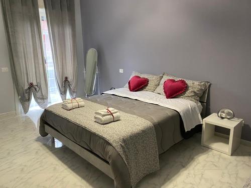 una camera da letto con un letto con cuscini rossi di Affittacamere Iria a Pomigliano dʼArco