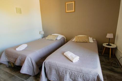 two beds in a room with towels on them at Hotel Carina in Apt