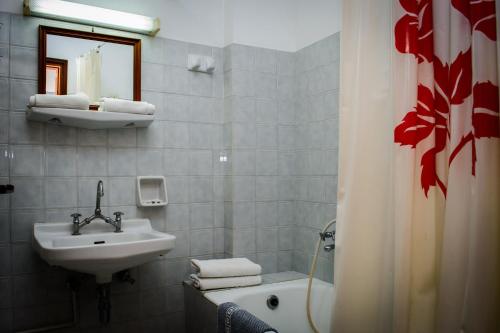 a bathroom with a sink and a bath tub at Nefeli Hotel in Karlovasi