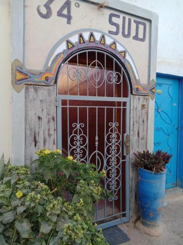 a door with a gate in the side of a building at Dar 34degrés Sud in Mirleft