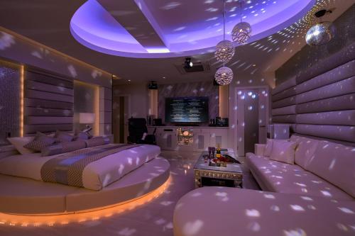 a purple bedroom with a bed and a couch at HOTEL Dior7つくば in Tsuchiura