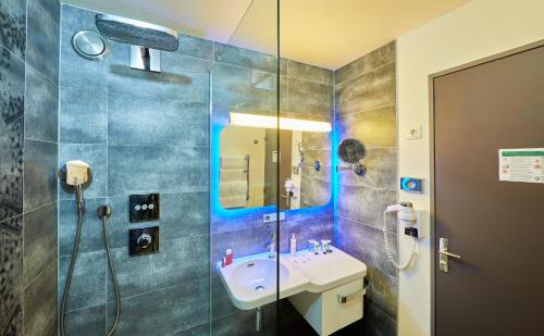 a bathroom with a sink and a shower at Le Thalassa Hôtel & Spa in Camaret-sur-Mer