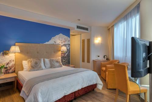 Schlafzimmer mit einem Bett und einem Flachbild-TV in der Unterkunft Hotel Sporting Trento in Trient