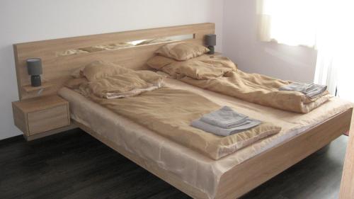 a large wooden bed with two pillows on it at HZ Apartman Miskolc in Miskolc