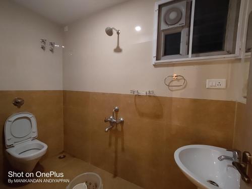 a bathroom with a toilet and a sink at Hotel Ramtel inn in Madurai