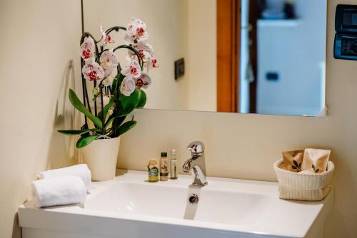 a bathroom sink with a vase of flowers on it at La Dolce Vita in Montecchia di Crosara