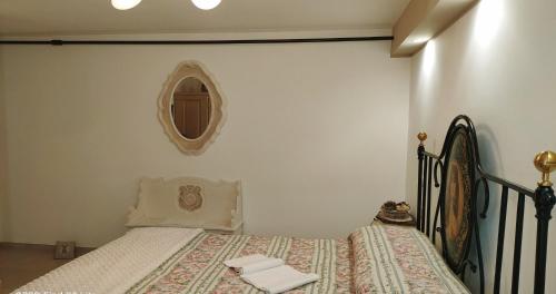 Mírame Casa Vacanza في أوفندولي: غرفة نوم مع سرير ومرآة على الحائط