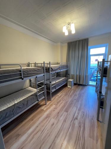 a dorm room with bunk beds and a large window at Mr Jo’s hostel in Kaunas