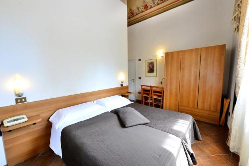a bedroom with a large bed with a wooden headboard at Hotel Iris in Perugia