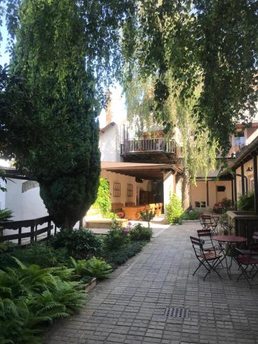 a courtyard with tables and chairs and a tree at Scheinerhaus in Laa an der Thaya