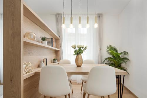 a dining room with a table and white chairs at VISIMO Apartments Chur in Chur