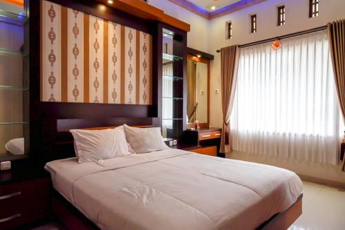 a bedroom with a large bed and a window at RedDoorz near MM UGM in Yogyakarta