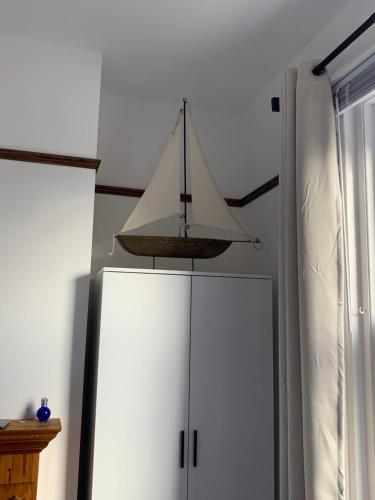 a sailboat hanging over a white refrigerator at Cosy 2 Bedroom House -2022 & 2023 Award Winner! in Ramsgate