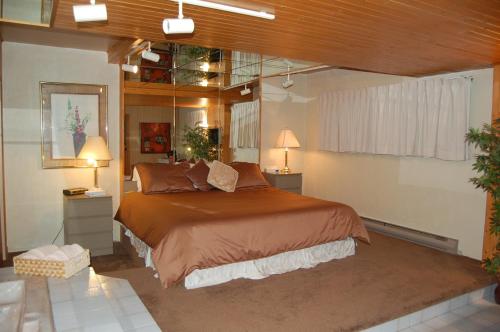 a bedroom with a large bed and two lamps at Auberge Godard in Nominingue