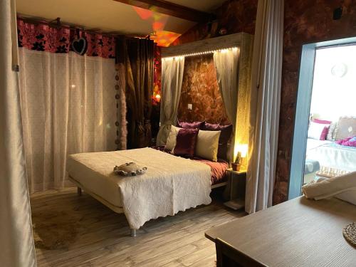 1 dormitorio con 1 cama en una habitación con cortinas en SUITE spa accès autonome, en Beaucaire