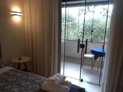 a hotel room with a bed and a sliding glass door at Aromas da Pedra in Pedra Azul