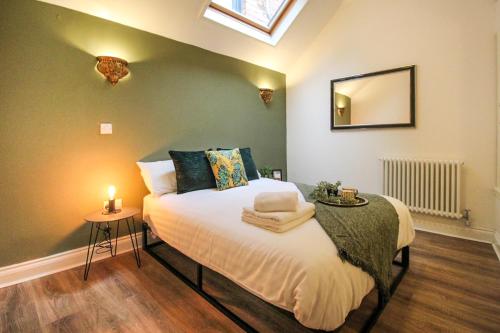 a bedroom with a bed with a mirror on the wall at 3 Bedroom City Centre Townhouse in Nottingham