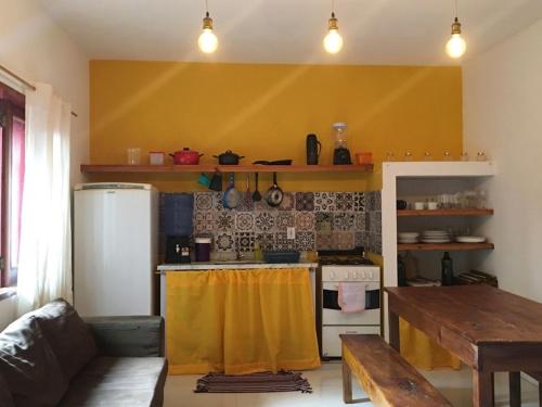 a kitchen with a stove and a table in a room at Vila Hibisco Itacaré in Itacaré