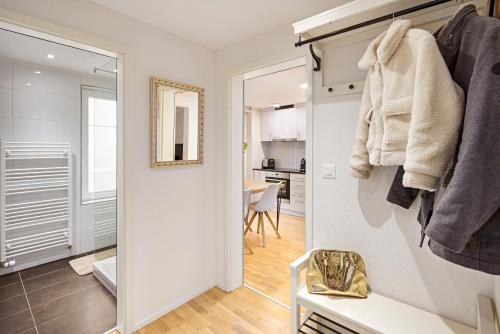 a white bathroom with a mirror and a room at EH Apartments Venus in St. Gallen