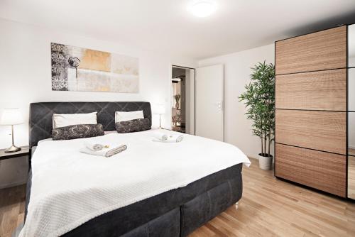 a bedroom with a large bed with white sheets at EH Apartments Venus in St. Gallen
