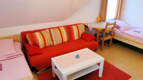salon z czerwoną kanapą i łóżkiem w obiekcie Charmantes Apartment in Mittelfeld w Hanowerze