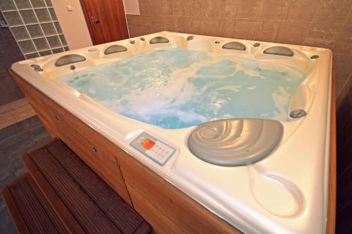 y baño con bañera de agua azul. en ApartSerwis - Apartament Paryski, en Zakopane