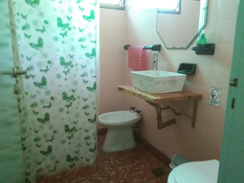 a bathroom with a sink and a toilet and a mirror at La Casa de Ramatis Posada in Valle Hermoso