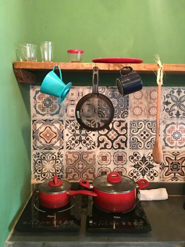 two pots and pans on a stove in a kitchen at Vila Hibisco Itacaré in Itacaré