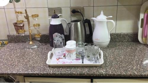 a counter with a tray of glass items on it at Al Marwa Apartment in Dokki - Families Only in Cairo