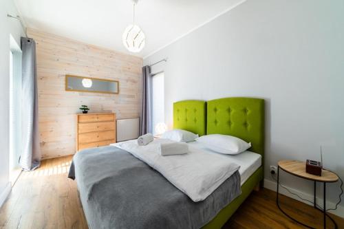 a bedroom with a large bed with a green headboard at Komfortowy Apartament w Karpaczu do 5 os. in Karpacz