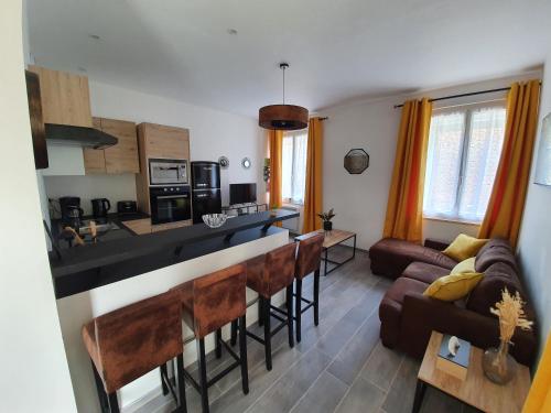 a kitchen and living room with a bar and a couch at Appartement chaleureux in Oignies