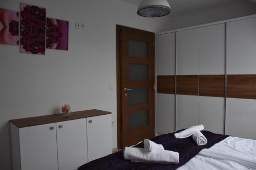 a bedroom with a bed and a cabinet with towels on it at Rubin Anett Apartman Sárvár in Sárvár