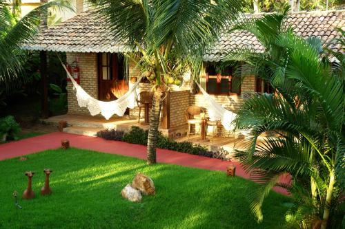 a house with a yard with a hammock in it at ThalassaGarden Hotel - Pousada in Pipa