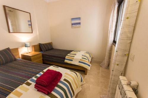 RodaにあるRODA Golf & Beach Resort Wonderful Ground Floor Apartmentのベッド2台とソファが備わる客室です。