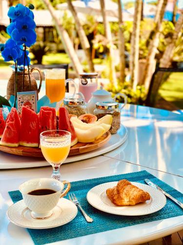 un tavolo con piatti di cibo e una tazza di caffè di Búzios House Oficial a Búzios