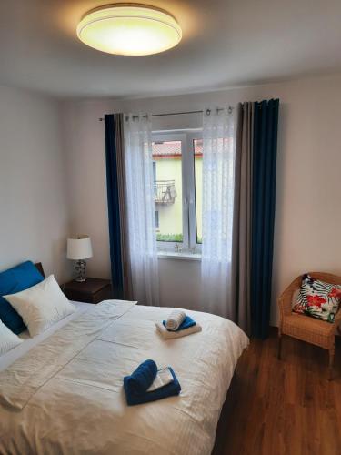 a bedroom with a bed with two slippers on it at Rowy Apartament.b5 in Rowy
