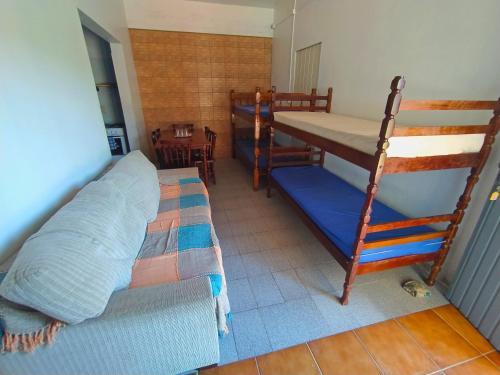a bedroom with two bunk beds and a couch at Pousada Colibris in Pinhal