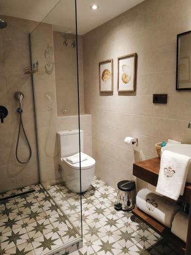 a bathroom with a toilet and a glass shower at Hotel Boutique Casa del Comendador in Navalcarnero