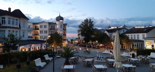 a town square with tables and chairs and a building at Hotel Meereswelle - Anno 1875 in Ahlbeck