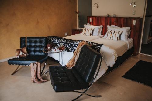 a bedroom with a bed and a chair and a table at Bloomestate Swellendam in Swellendam