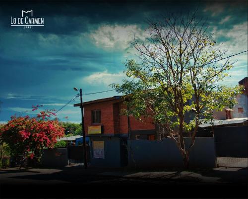 a tree in front of a brick building at Lo de Carmen Apart in Puerto Iguazú