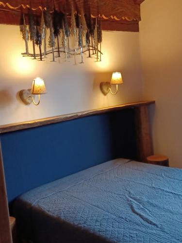 a bedroom with a bed with two lights on the wall at Le Trédard magnifique chalet 10 personnes face aux 3 vallées sur les hauteurs de Bozel in Feissons-sur-Salins