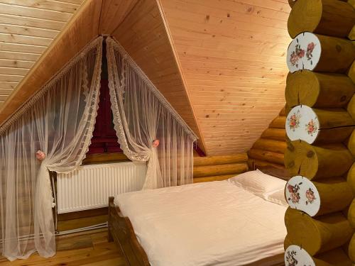 ヤブルニツァにあるЕко котедж Яблуницька трояндаの木製の部屋にベッド1台が備わるベッドルーム1室があります。