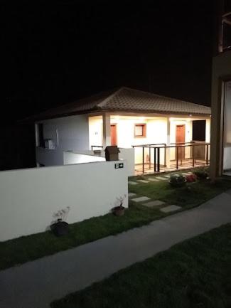 a white fence in front of a house at night at Aromas da Pedra in Pedra Azul
