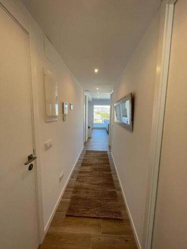 a hallway with a long hallway with a door and a rug at L'ARMONIA entre la Farella i Cau del LLOP in Llança