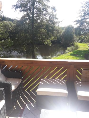 a deck with benches and a view of a river at Le Grand Chalet in La Chapelle