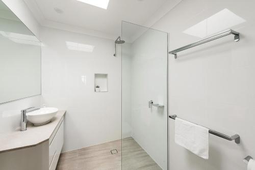 a bathroom with a toilet, sink, and shower stall at Beach House Holiday Apartments in Port Macquarie