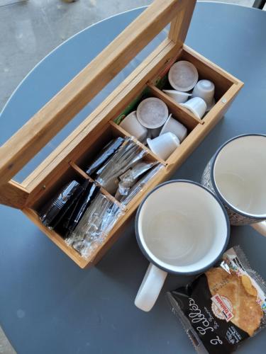 a table with a wooden tray with eggs and a cup at Le Cottage de la Doucette in Paimpont
