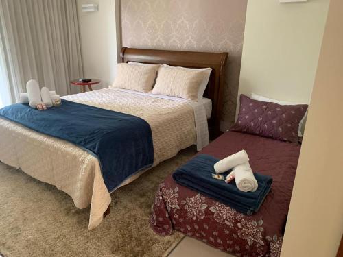 a bedroom with two beds with towels and a window at Aromas da Pedra in Pedra Azul